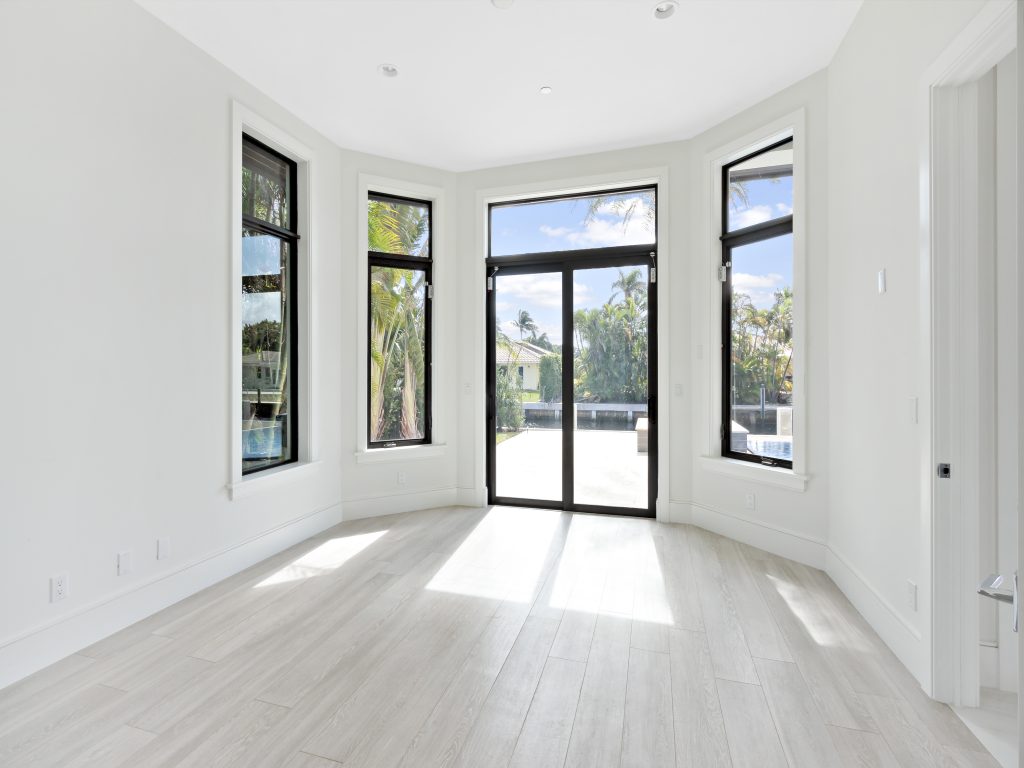Bright room with black-frame impact windows and French doors